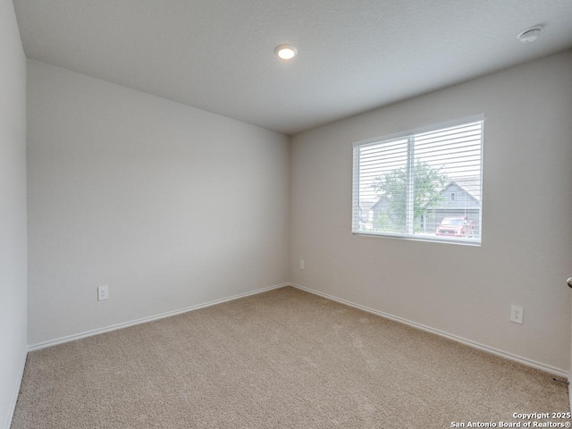 empty room with baseboards and light carpet