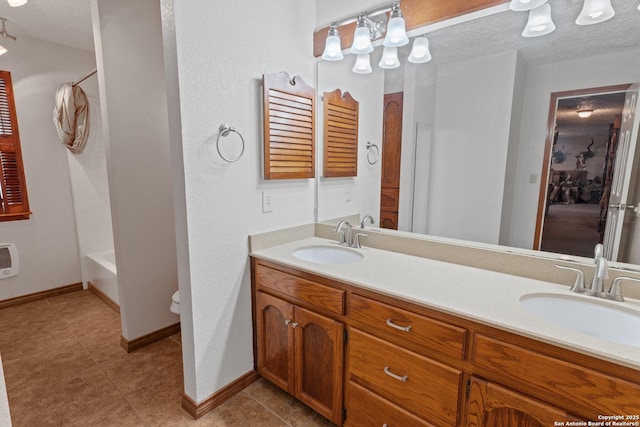 full bath featuring baseboards, shower / bathing tub combination, double vanity, and a sink