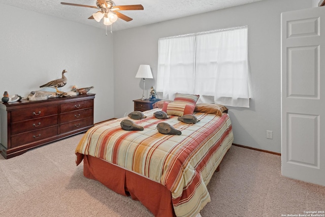 bedroom with a ceiling fan, a textured ceiling, carpet, and baseboards
