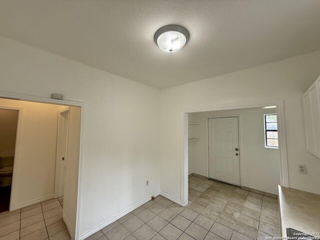 interior space featuring a textured ceiling and light tile patterned floors