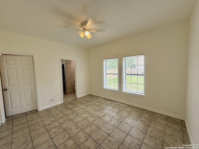 spare room featuring light tile patterned floors, a ceiling fan, and baseboards