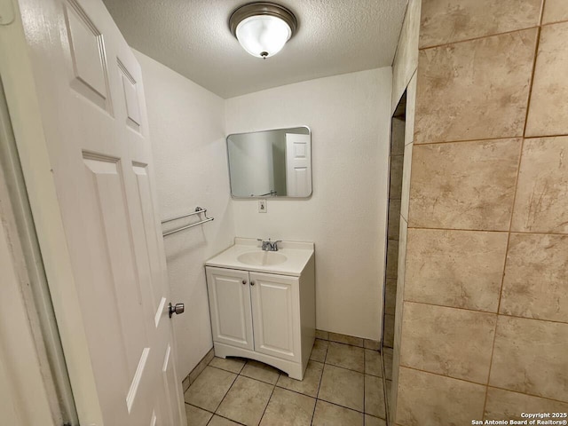 bathroom featuring tile patterned floors, a textured ceiling, and vanity