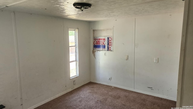 carpeted spare room with baseboards
