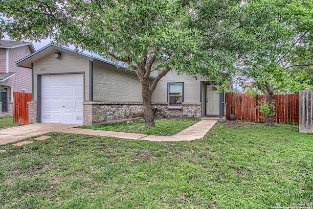 single story home with brick siding, fence, a front lawn, concrete driveway, and an attached garage