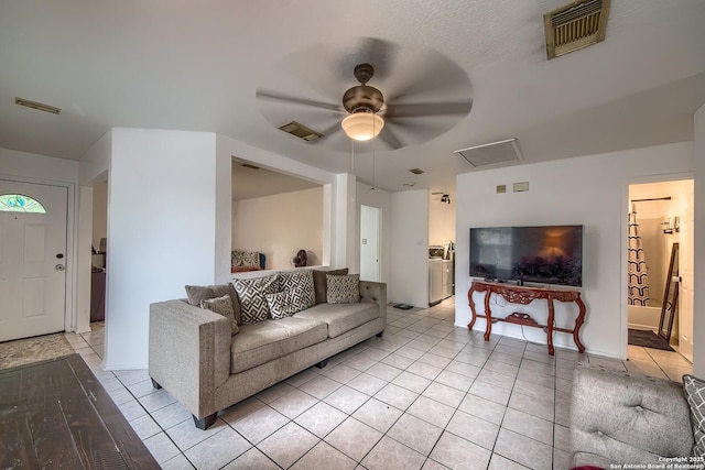 living room featuring light tile patterned floors, visible vents, and a ceiling fan