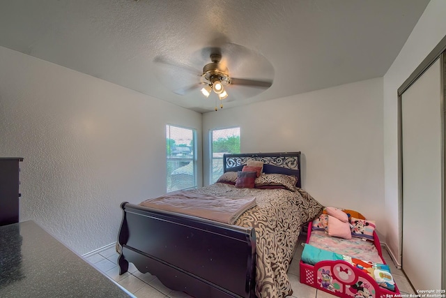 bedroom featuring a ceiling fan, tile patterned floors, and baseboards