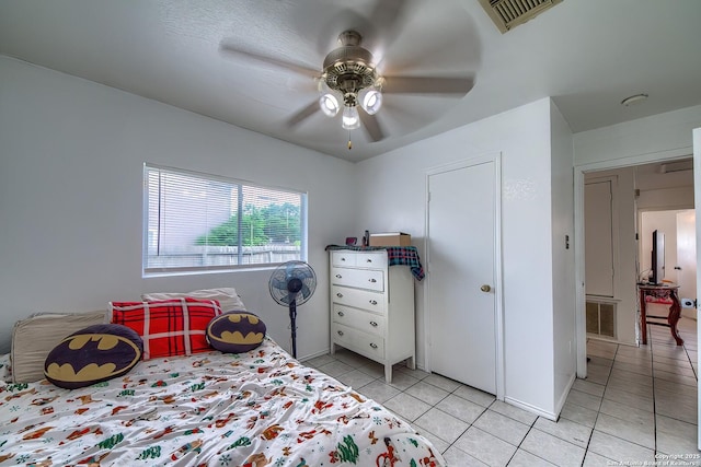 bedroom with light tile patterned flooring, visible vents, and ceiling fan