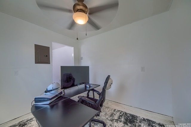 home office featuring wood finished floors, ceiling fan, and electric panel