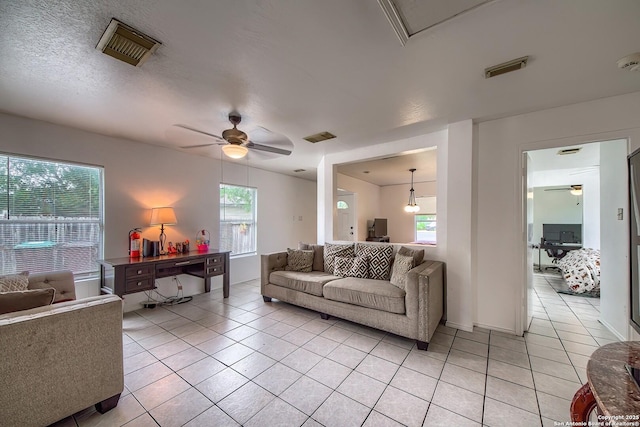 living room with light tile patterned floors, ceiling fan, and visible vents