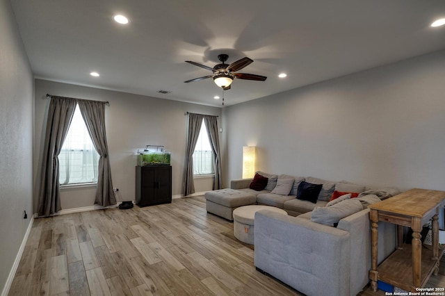 living area featuring baseboards, recessed lighting, a ceiling fan, and light wood-style floors