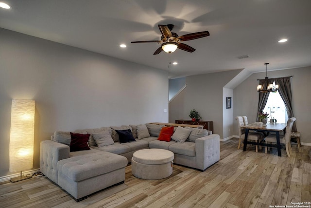living room with recessed lighting, visible vents, light wood-style flooring, baseboards, and ceiling fan with notable chandelier