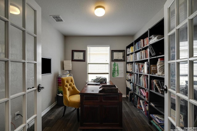 office featuring dark wood-type flooring, visible vents, a textured ceiling, and baseboards