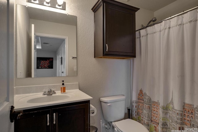 bathroom with toilet, vanity, and a shower with shower curtain