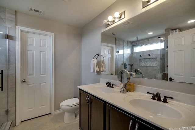 full bathroom featuring toilet, a stall shower, double vanity, and a sink