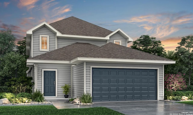 view of front of home featuring roof with shingles, concrete driveway, and a garage