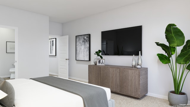 bedroom with ensuite bath, light colored carpet, and baseboards