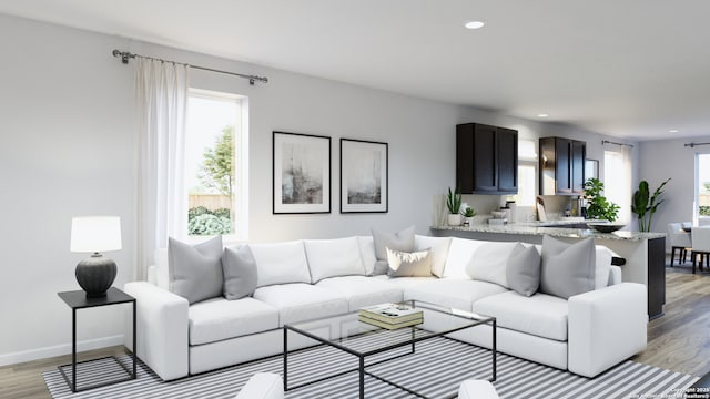 living area with a wealth of natural light, recessed lighting, light wood-style flooring, and baseboards