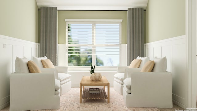 sitting room with a wainscoted wall, a wealth of natural light, and a decorative wall