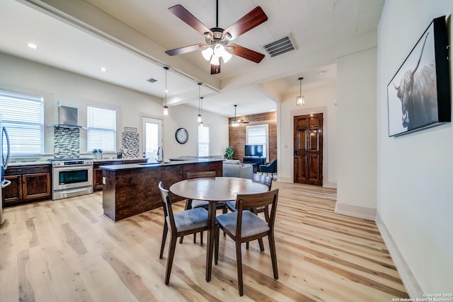 dining area featuring baseboards, visible vents, a ceiling fan, and light wood finished floors