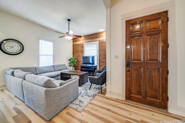 living room featuring a ceiling fan, light wood-style flooring, and baseboards