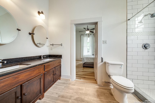 ensuite bathroom featuring a tile shower, toilet, ensuite bath, and a sink