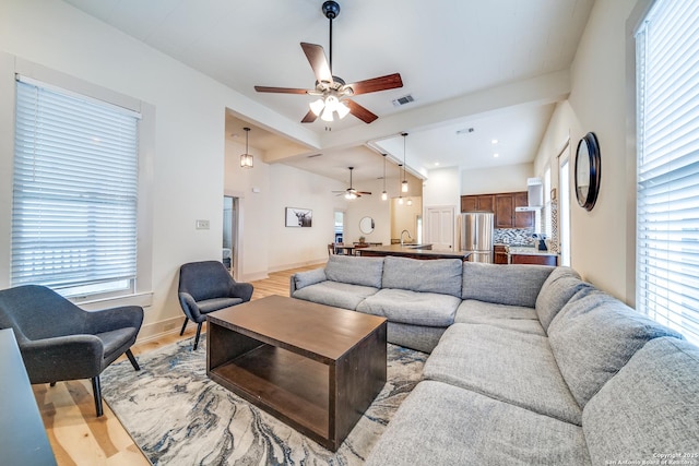 living room featuring a healthy amount of sunlight, a ceiling fan, and light wood finished floors
