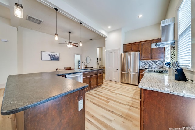 kitchen with a sink, stainless steel appliances, light wood-style floors, ceiling fan, and visible vents