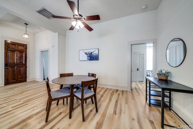 dining space with light wood-style floors, ceiling fan, visible vents, and baseboards