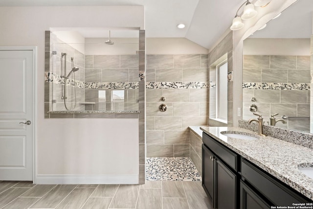 full bathroom with double vanity, a sink, a walk in shower, and recessed lighting