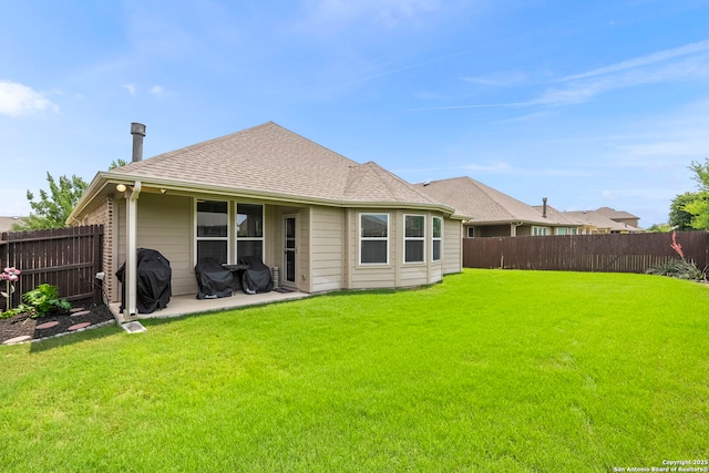 back of house with a fenced backyard and a yard