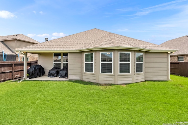 rear view of house with a patio area, fence, and a yard
