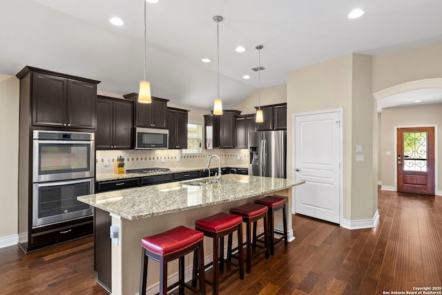 kitchen featuring a sink, appliances with stainless steel finishes, dark wood finished floors, and tasteful backsplash