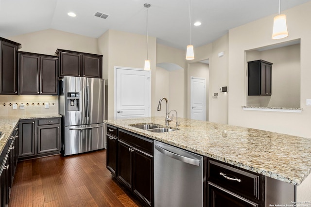 kitchen with visible vents, dark wood-type flooring, light stone counters, a sink, and appliances with stainless steel finishes