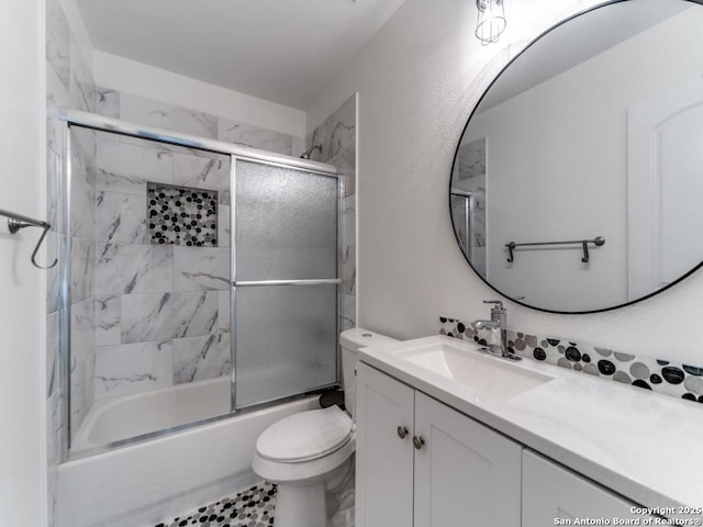 bathroom featuring shower / bath combination with glass door, toilet, and vanity