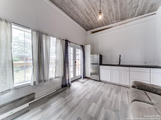 unfurnished living room featuring wooden ceiling, a wealth of natural light, light wood-style flooring, and a sink