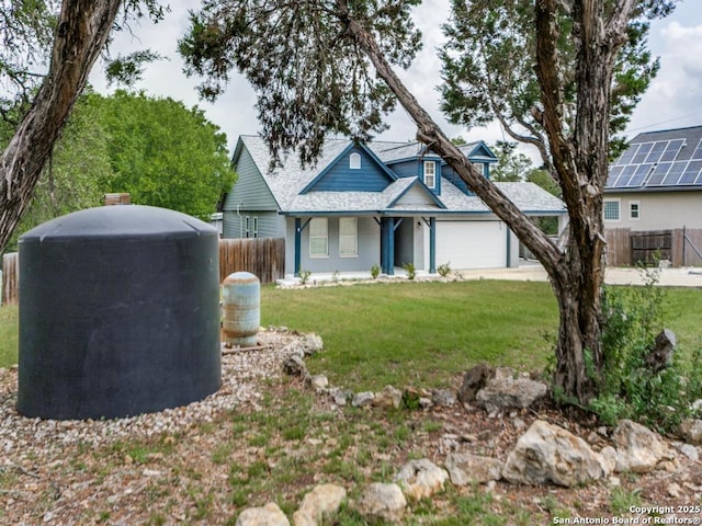 view of front of house with fence, a front yard, and an attached garage