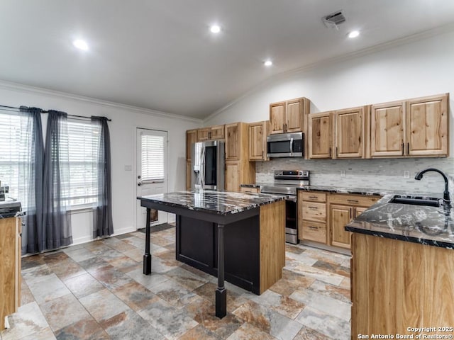 kitchen featuring dark stone countertops, a kitchen breakfast bar, a sink, and stainless steel appliances