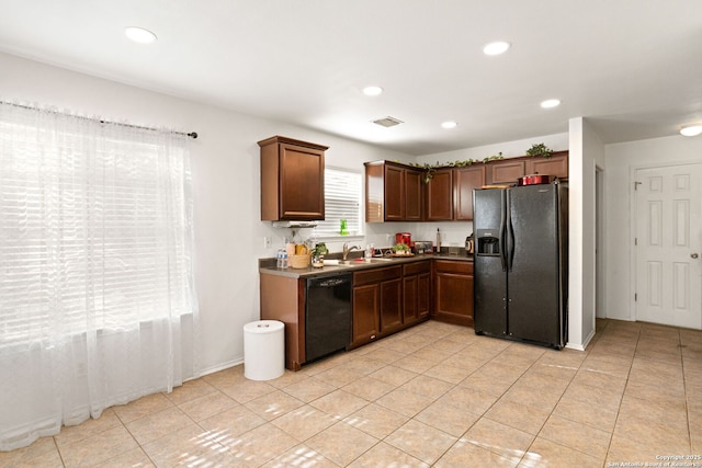 kitchen with recessed lighting, black appliances, light tile patterned floors, and a sink