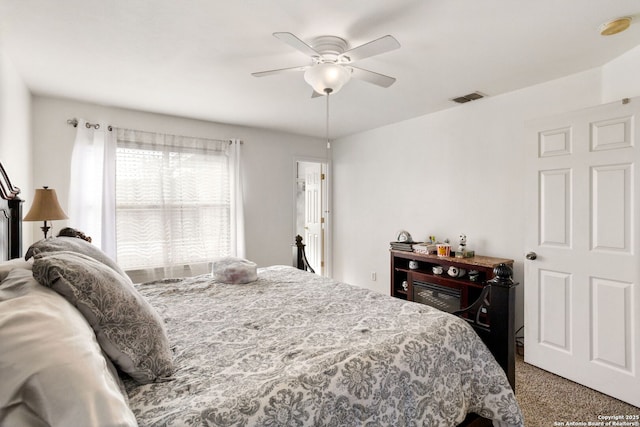 carpeted bedroom with visible vents and a ceiling fan