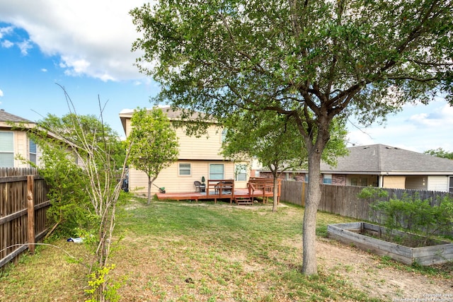 view of yard featuring a fenced backyard, a wooden deck, and a vegetable garden