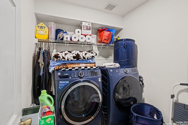clothes washing area with independent washer and dryer, visible vents, and laundry area