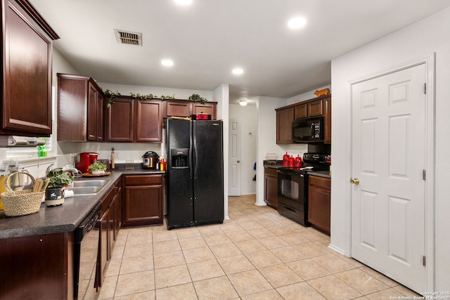 kitchen with light tile patterned floors, dark brown cabinets, black appliances, dark countertops, and visible vents