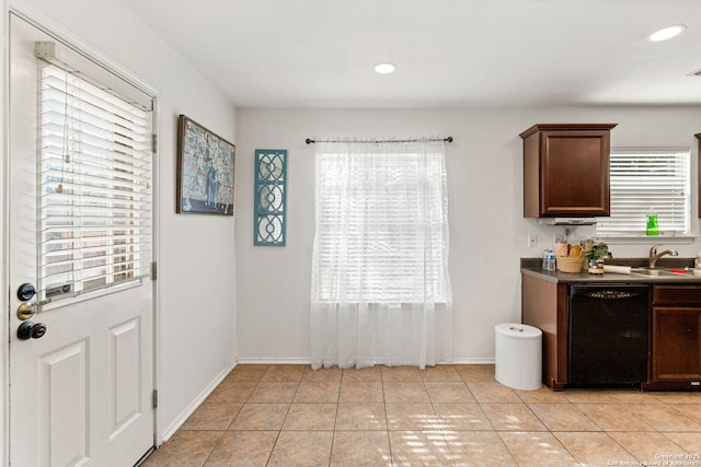 kitchen with a sink, dark countertops, light tile patterned flooring, recessed lighting, and black dishwasher