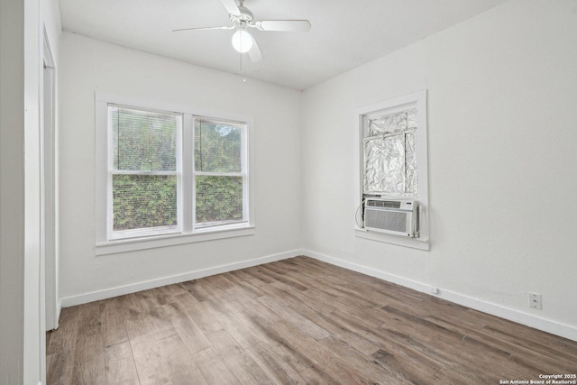 spare room featuring baseboards, wood finished floors, and cooling unit