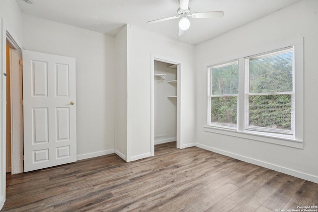 unfurnished bedroom with a closet, a ceiling fan, wood finished floors, and baseboards
