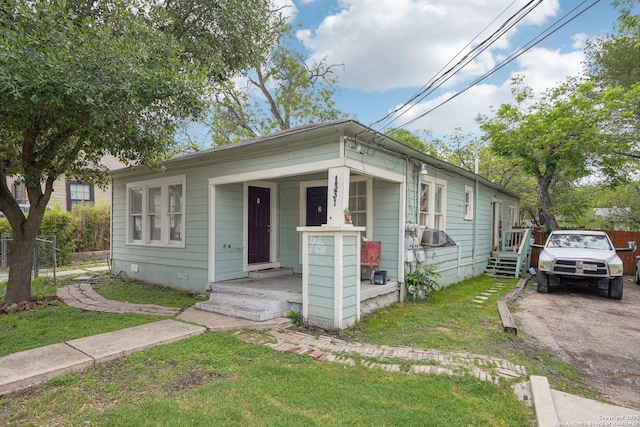 shotgun-style home with a front yard, a porch, and crawl space