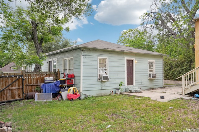 back of property with a lawn, fence, a gate, and a patio area