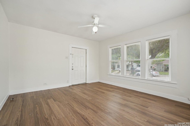 unfurnished room featuring baseboards, wood finished floors, and ceiling fan