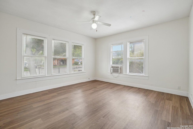spare room featuring baseboards, wood finished floors, and ceiling fan