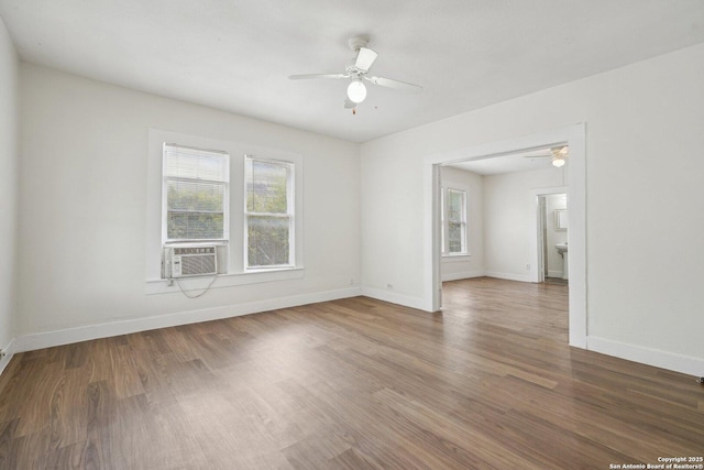 spare room featuring wood finished floors, a ceiling fan, cooling unit, and baseboards